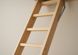 Close-up view of a well-designed wooden loft ladder against a neutral wall